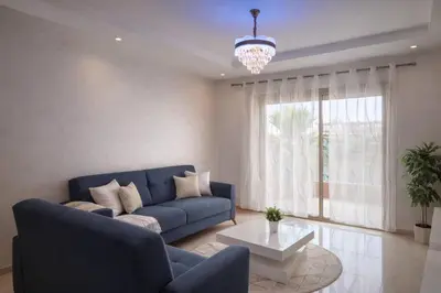 a living room with a blue couch and a table at Marrakech prestige in Marrakech