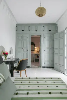 a living room with a table and a chair at Riad Palazzo Montefiore in Marrakech