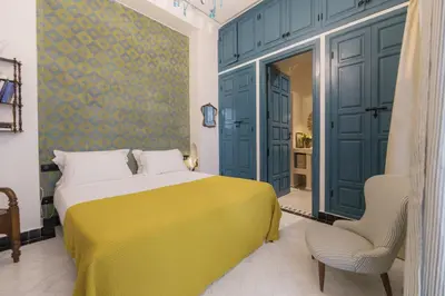 a bedroom with a yellow bed and a chair at Riad Palazzo Montefiore in Marrakech