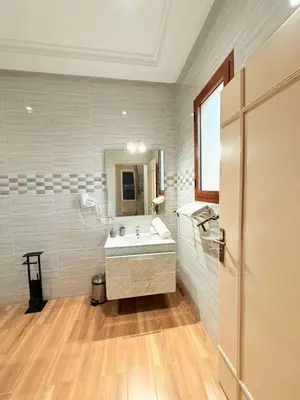 a white bathroom with a sink and a mirror at Villa ghina in Marrakech