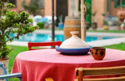a red table with a vase on top of it at Al Qaria Syahia Duplex Moufid in Marrakech