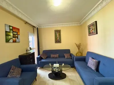 a living room with blue couches and a glass table at Trésor de Gueliz avec Piscine et Terrasse in Marrakech