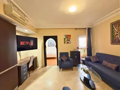 a living room with a blue couch and a table at Trésor de Gueliz avec Piscine et Terrasse in Marrakech