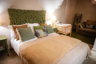 a bedroom with a large bed and a couch at Riad Secret by Dar n alla in Marrakech
