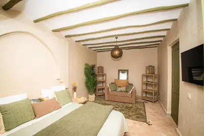 a bedroom with a bed and a living room at Riad Secret by Dar n alla in Marrakech