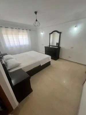 a bedroom with a bed and a dresser and a mirror at Prestigieux Appart hivernage in Marrakech