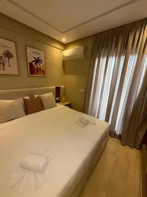 a bedroom with a large white bed and a window at Appartement de luxe à gueliz neuf et moderne in Marrakech