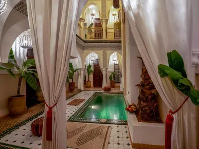 a swimming pool in a room with a building at Riad Fleur De Sable in Marrakech