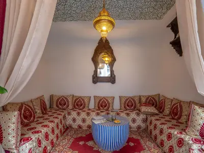 a living room with a couch and a chandelier at Riad Fleur De Sable in Marrakech