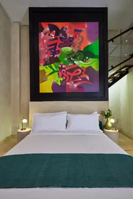 a bedroom with a white bed with a painting above it at Zen Zone Boutique Riad & Spa in Marrakech