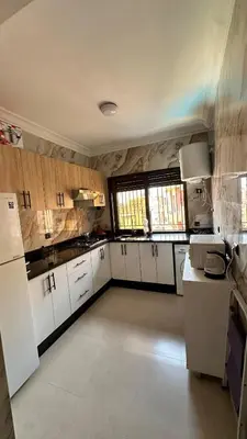 a large kitchen with white cabinets and white appliances at Sofia Palmeraie - High standing in Marrakech