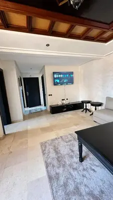 a living room with a couch and a tv on the wall at Sofia Palmeraie - High standing in Marrakech