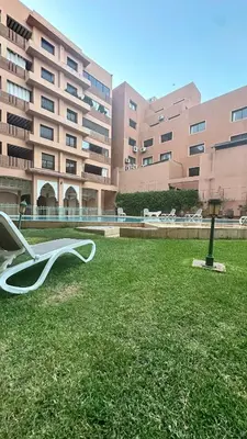 a white chair sitting in the grass in front of a building at Sofia Palmeraie - High standing in Marrakech