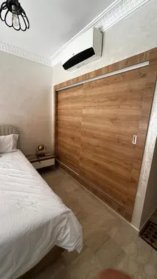 a bedroom with a wooden wall and a bed at Luxury & Cozy Apt in Hivernage in Marrakech