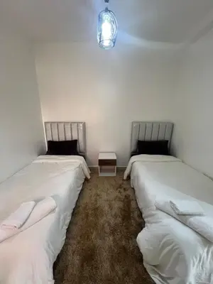 two beds in a room with white sheets at Peaceful Marrakech Stay Cozy Well Located in Marrakech