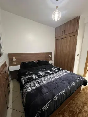 a bedroom with a large bed with a wooden headboard at Peaceful Marrakech Stay Cozy Well Located in Marrakech