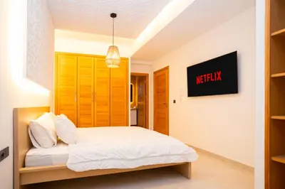 a bedroom with a bed and a tv on the wall at Villa Meraki in Marrakech
