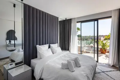 a bedroom with a large white bed and a balcony at Villa Tiaré Luxury, pool, staff and private cinema in Marrakech