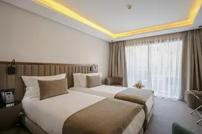 a hotel room with two beds and a window at NearYo Hotels in Marrakech