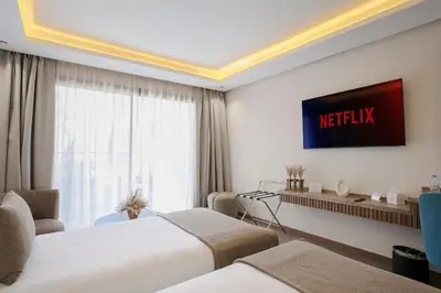 a hotel room with two beds and a tv at NearYo Hotels in Marrakech