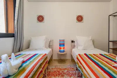 a bedroom with two beds and a striped rug at Marrakech Duplex Haut Standing, Piscine et Jardin Privé in Marrakech