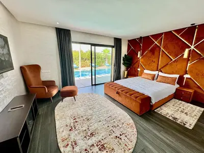 a bedroom with a king sized bed and a chair at Villa exclusive Ourika piscine sans vis-à-vis in Segraga