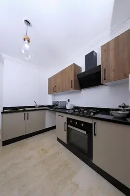 a kitchen with white walls and black counter tops at 2 Bedroom flat - Marrakech in Marrakech