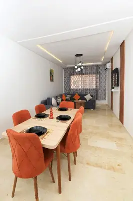 a dining room with a table and orange chairs at 2 Bedroom flat - Marrakech in Marrakech
