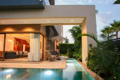 a house with a swimming pool in front of a house at Villa Aria Marrakech in Marrakech