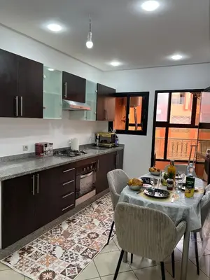 a kitchen with a table and chairs in a kitchen at Super apt plein centre de Gueliz hyper bien placer pour votre séjour tout à proximité resto café transport in Marrakech