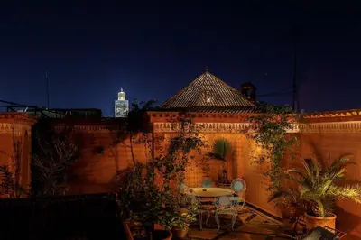 a patio with a table and some plants and a building at Riad Bleu-Azrak in Marrakech