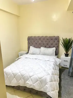 a bedroom with a bed with a white comforter at Bright Modern Apartment Marrakech City Center, Walk Everywhere in Marrakech