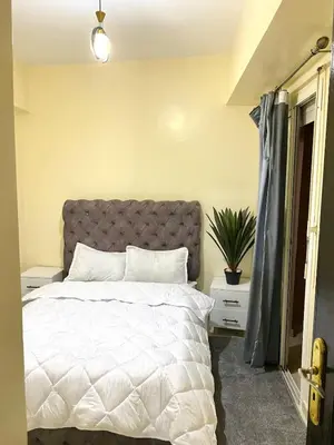a bedroom with a white bed with a gray headboard at Bright Modern Apartment Marrakech City Center, Walk Everywhere in Marrakech