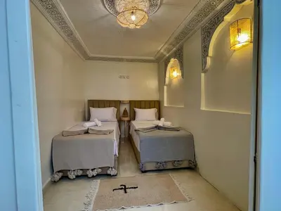 a room with two beds and a chandelier at Dar Salomi in Marrakech