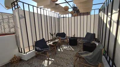 a balcony with four chairs and a fence at Maison en exclusivité 2 chambre Place Jemma El Fna in Marrakech