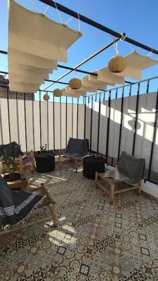 a room with chairs and umbrellas on a roof at Maison en exclusivité 2 chambre Place Jemma El Fna in Marrakech