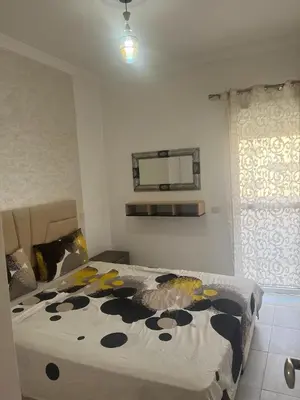 a bedroom with a bed with a black and yellow blanket at appartement sadaa in Marrakech