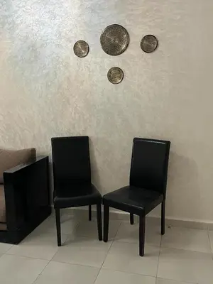two black chairs and coins on a wall at appartement sadaa in Marrakech