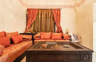 a living room with a couch and a coffee table at Résidence riad jawhara in Marrakech