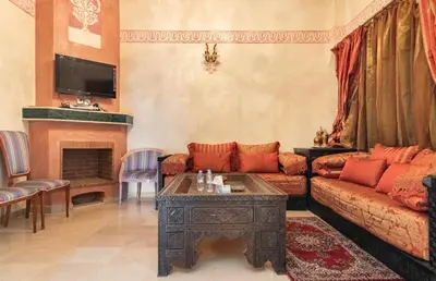 a living room with a couch and a table at Résidence riad jawhara in Marrakech
