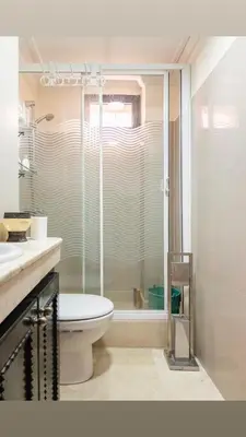 a bathroom with a toilet and a glass shower at Résidence riad jawhara in Marrakech