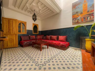 a living room with a red couch and a table at Antaki retreat Marrakech in Marrakech