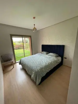 a bedroom with a bed and a large window at Le villagois in Marrakech