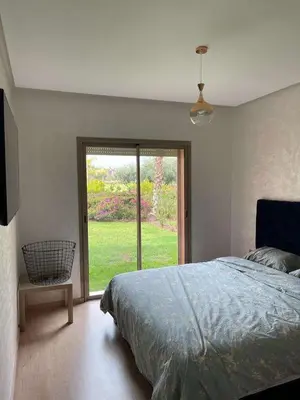 a bedroom with a bed and a large window at Le villagois in Marrakech