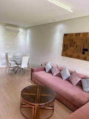a living room with a pink couch and a table at Le villagois in Marrakech