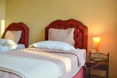 a bedroom with two beds and a lamp on a table at Palmeraie Stay - Pool & Lake in Marrakech