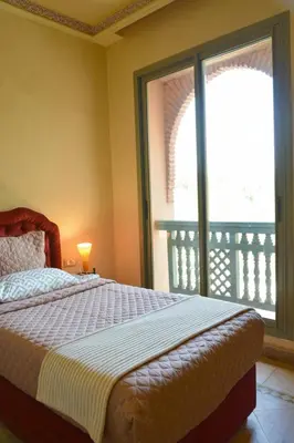 a bedroom with a bed and a large window at Palmeraie Stay - Pool & Lake in Marrakech