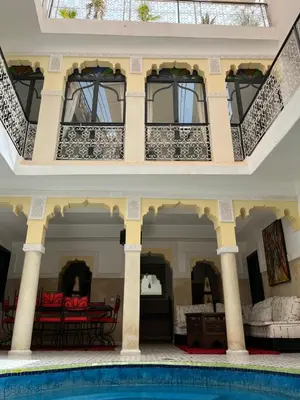 a villa with a swimming pool and a balcony at Riad Miliana in Marrakech