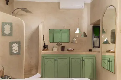 a bathroom with green cabinets and a sink at Riad Privé Dar El Khamsa-Petit Dej inclus in Marrakech