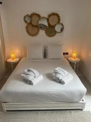 a white bed with towels on it with two lights at RIAD Al QARYA 4 chambres in Marrakech